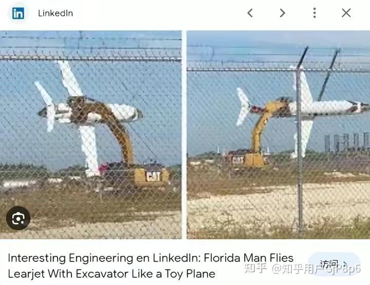 An excavator's arm appears to be holding up a small airplane behind a chain link fence. (Captioned by AI)