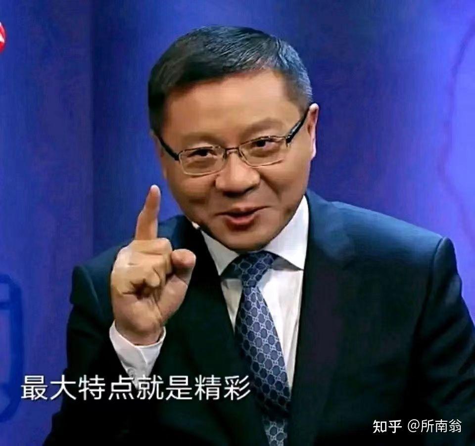 A man in a suit and glasses is pointing his index finger upwards, seemingly making a point during a speech or presentation. (Captioned by AI)