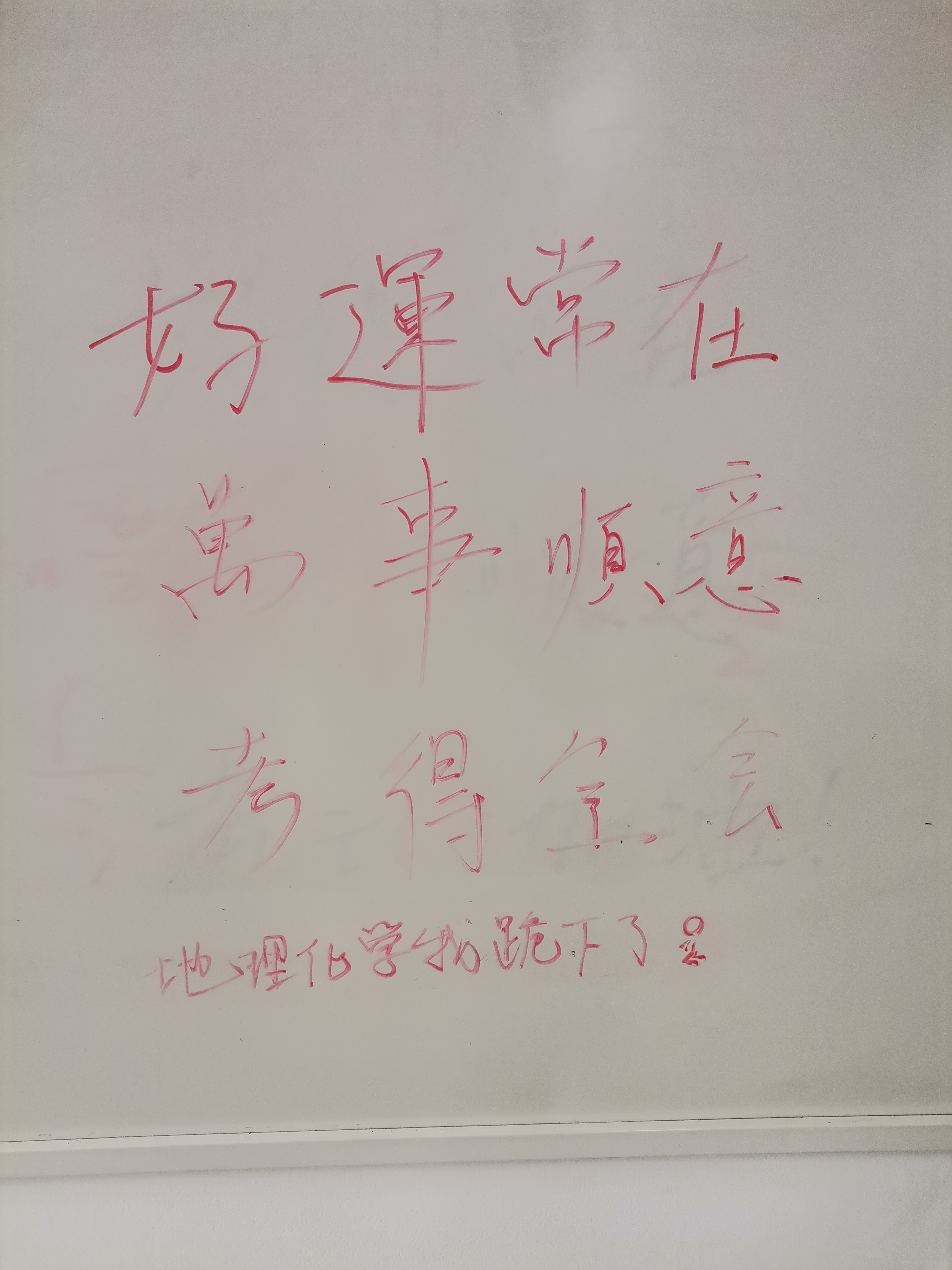 A whiteboard contains Chinese characters written in red marker, potentially a motivational or instructional message. (Captioned by AI)