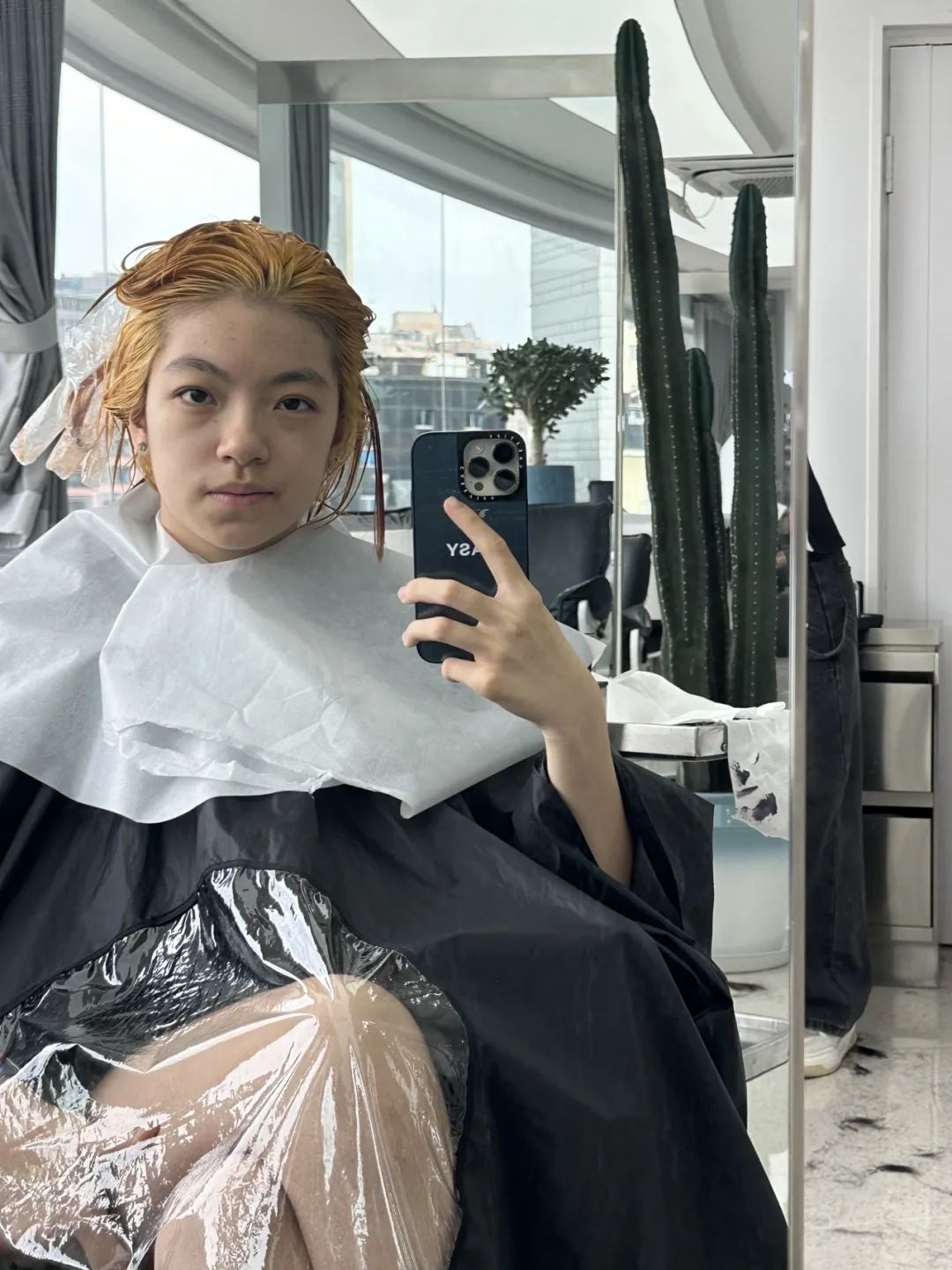 A person with bleach in their hair takes a selfie while at a hair salon. (Captioned by AI)