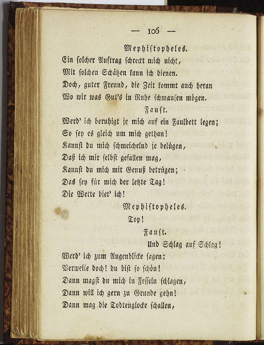 The image shows an open book with a page displaying a portion of a play written in a Fraktur typeface, likely German. (Captioned by AI)